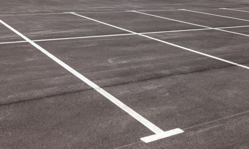 White parking bay — park between cars in marked white spaces where rules allow